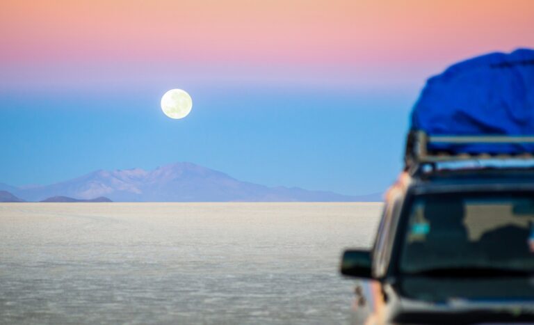 Full moon sunset with off road jeep vehicle on Salar De Uyuni